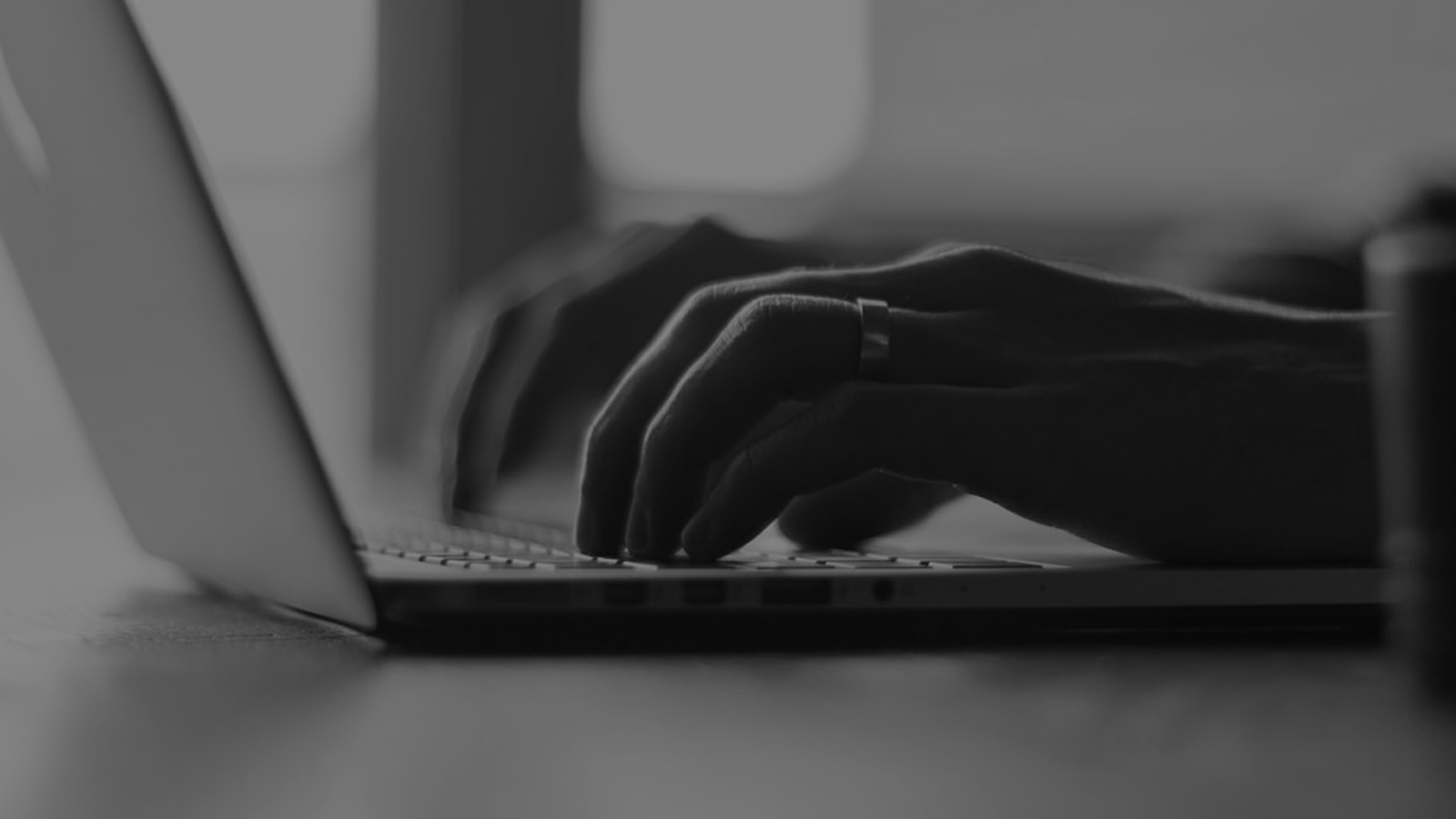 Close-up of hands typing on a laptop.