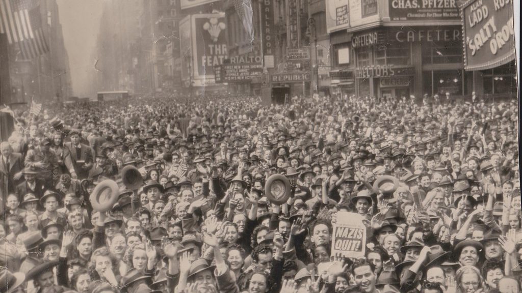 Black and white image of a crowd of people celebrating the end of World War 2.