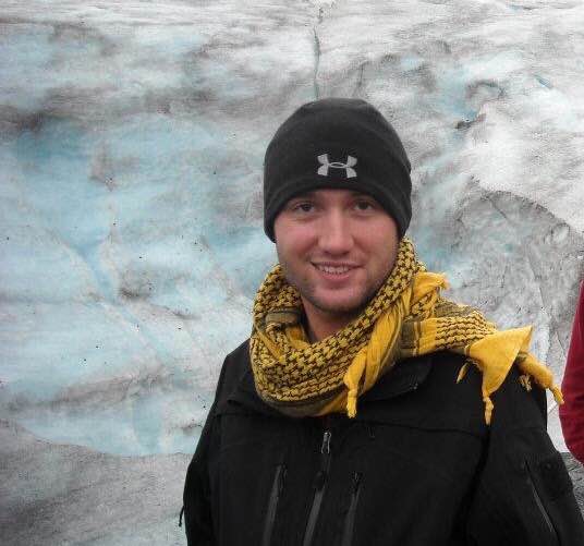 Josh Stevens stands near a glacier