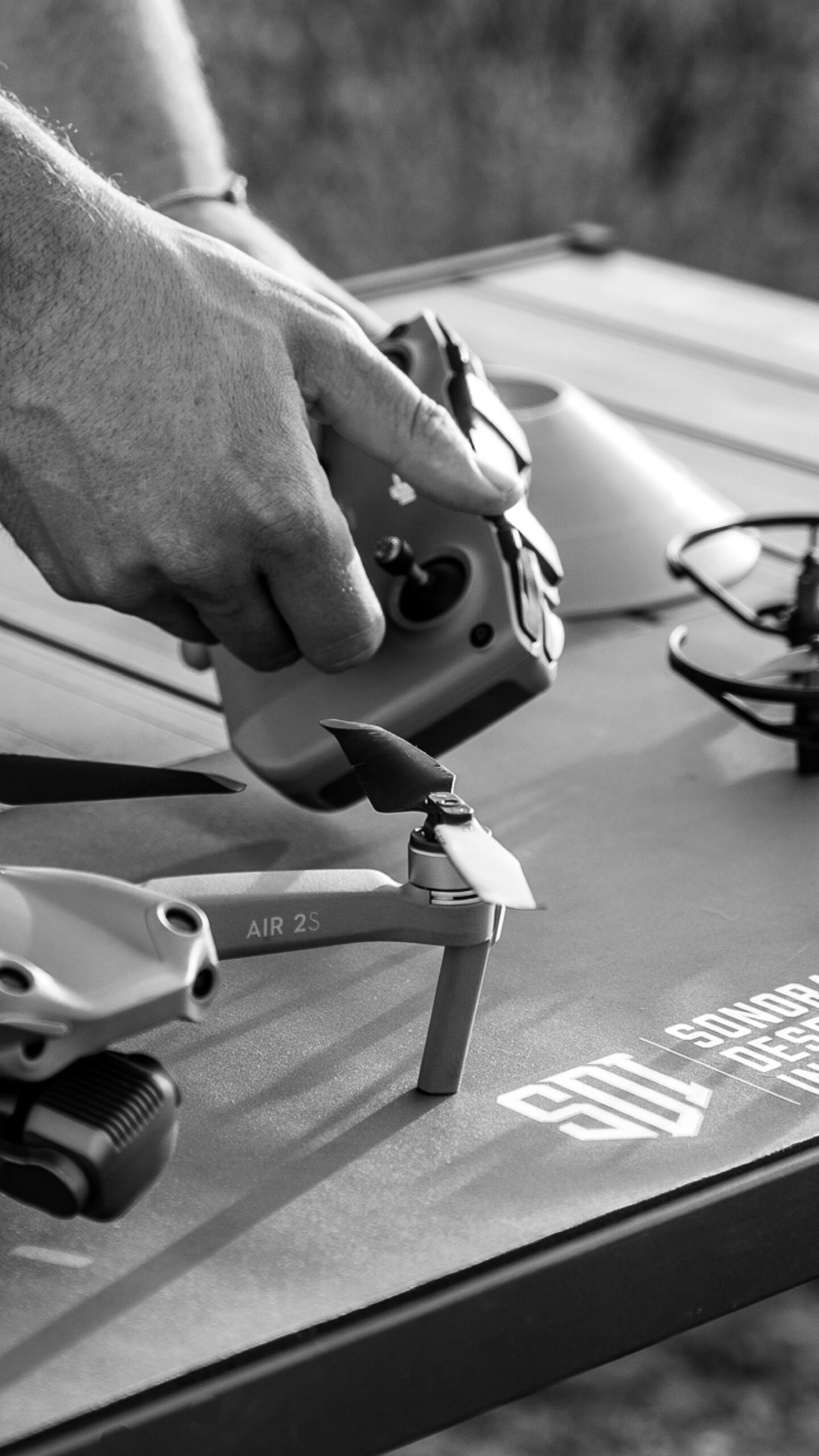 A black and white photo of a man working on a drone controller