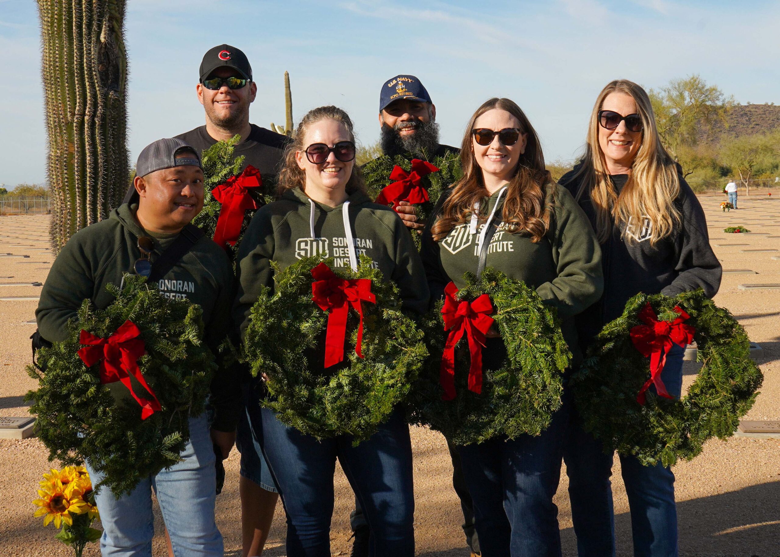 Volunteers from Sonoran Desert Institute pose for a photo during Wreaths Across America's annual wreath laying at the National Memorial Cemetery of Arizona.