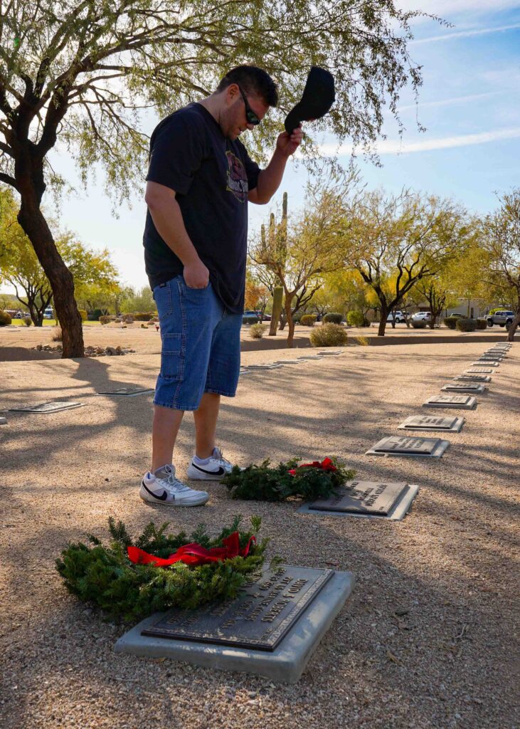 Rob Exham, Sonoran Desert Institute's Vice President of Student Finance, honors the fallen during Wreaths Across America's annual wreath laying at the National Memorial Cemetery of Arizona.