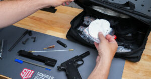 Firearms cleaning kit and parts laid out on SDI mat