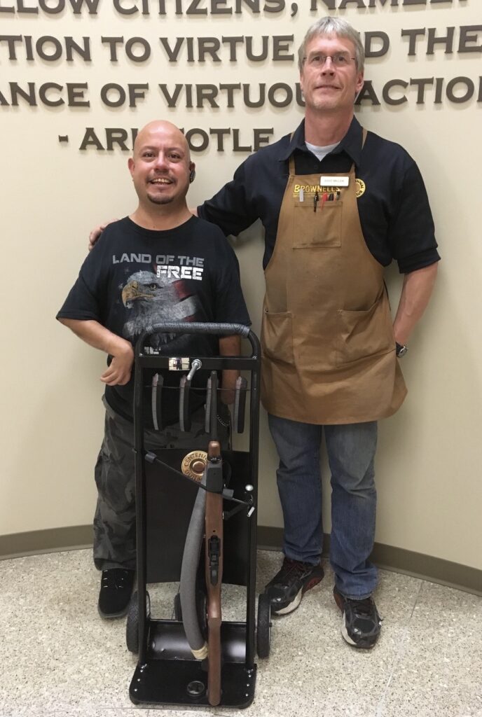 Bart Miller with a customer and the modified mobility cart he designed for independent rifle shooting
